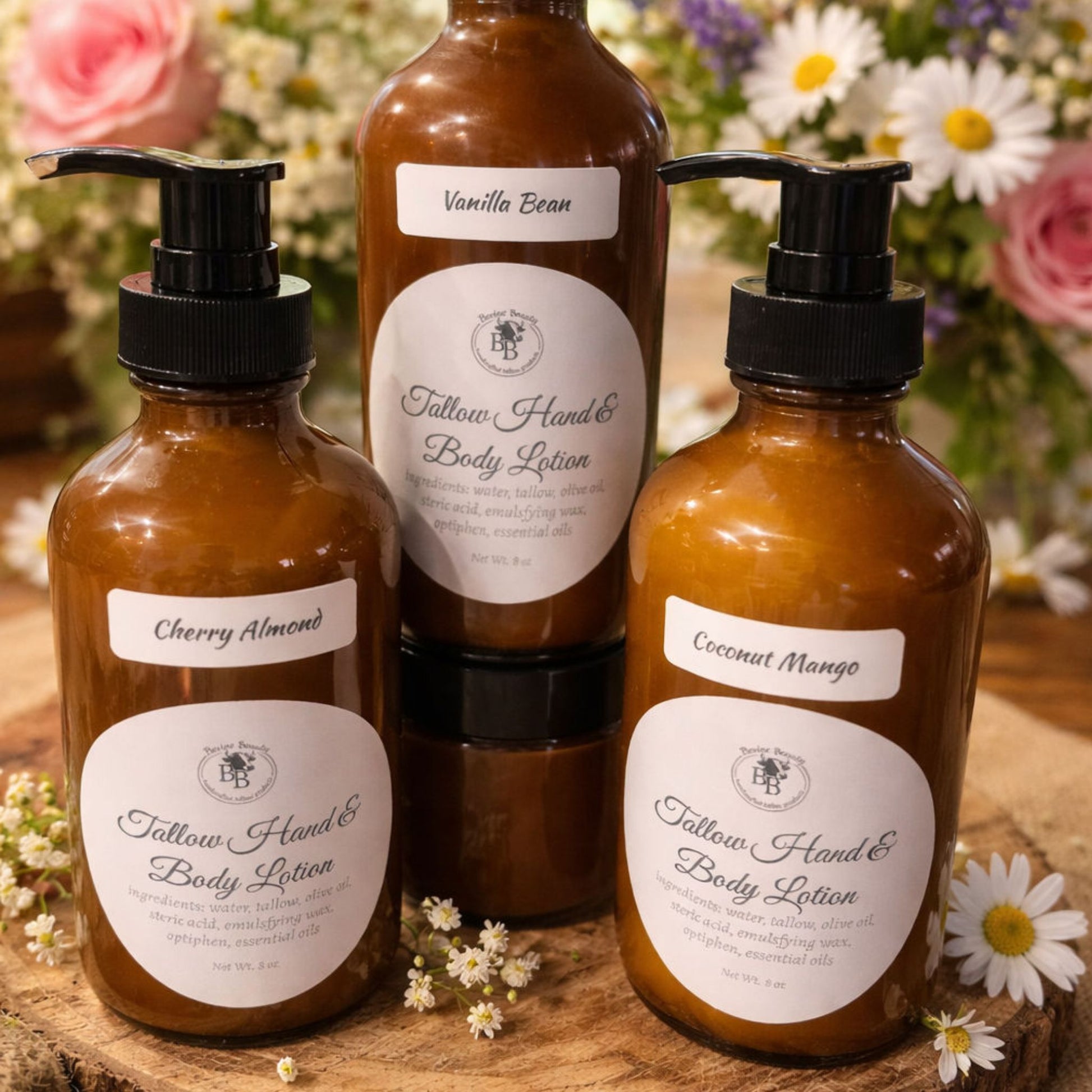 Three bottles of Tallow Hand & Body Lotion with labels on a wooden surface surrounded by flowers.