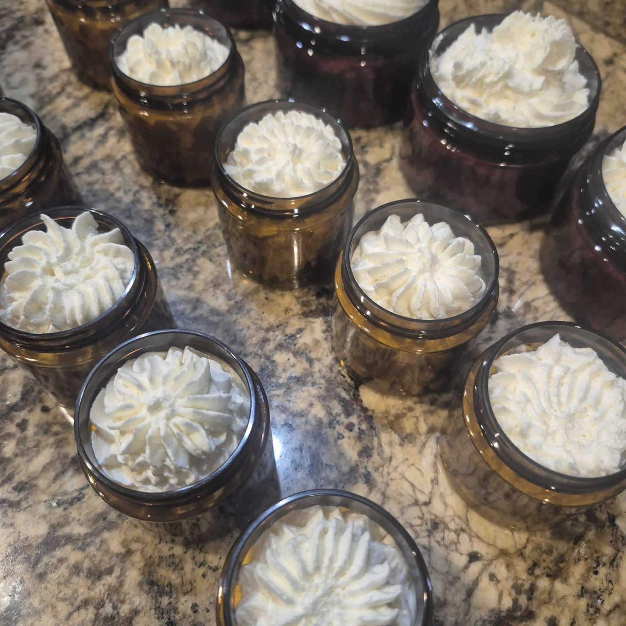 jars with whipped tallow and no lid  on a marble surface