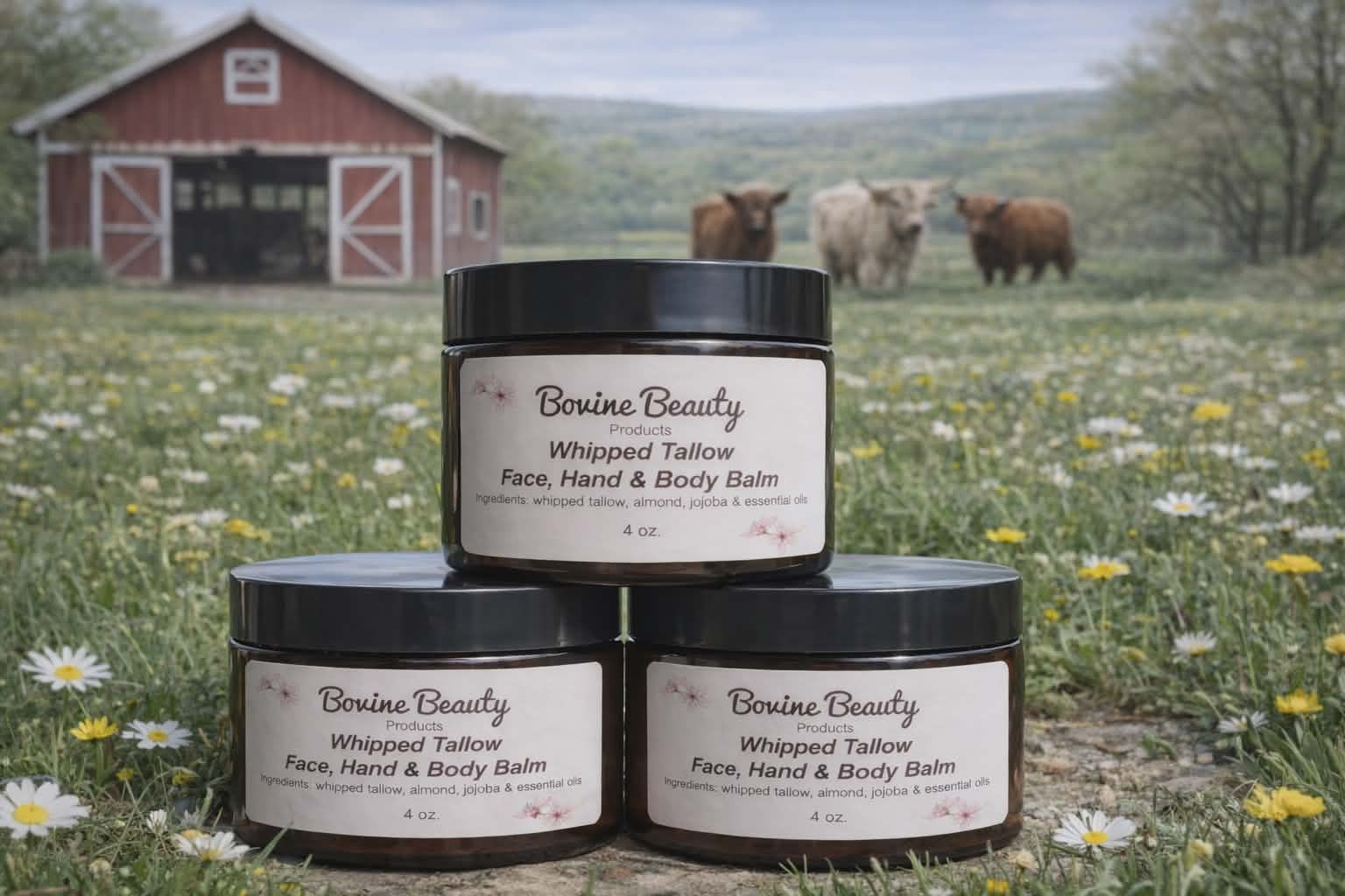 Three jars of Bovine Beauty Whipped Tallow Face, Hand & Body Balm stacked in a field with cows and a barn in the background.